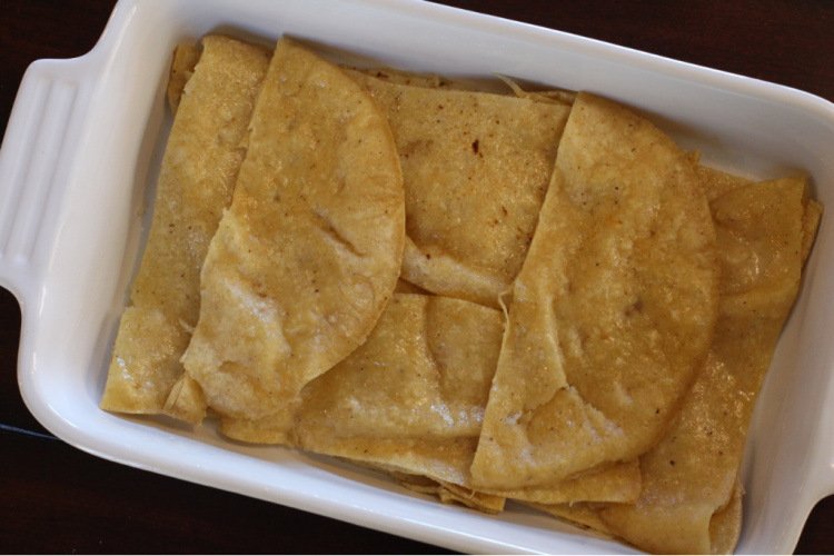 lining a casserole dish with fried corn tortillas