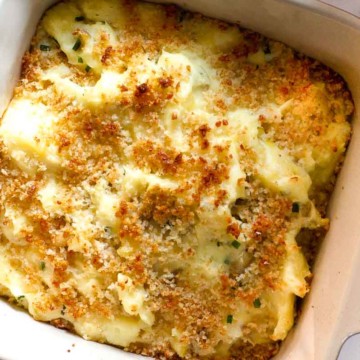 Sour cream mashed potatoes baked in a casserole dish.