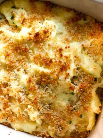 Sour cream mashed potatoes baked in a casserole dish.