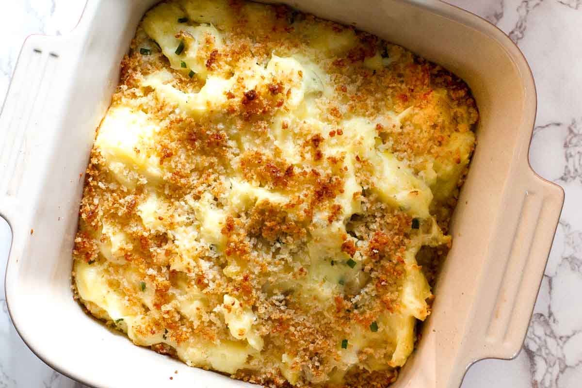 Sour cream mashed potatoes baked in a casserole dish.