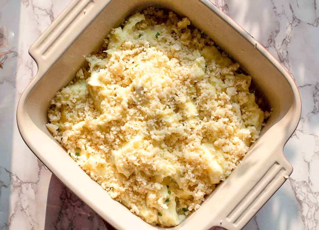 Sour cream mashed potatoes in a casserole dish ready to bake.