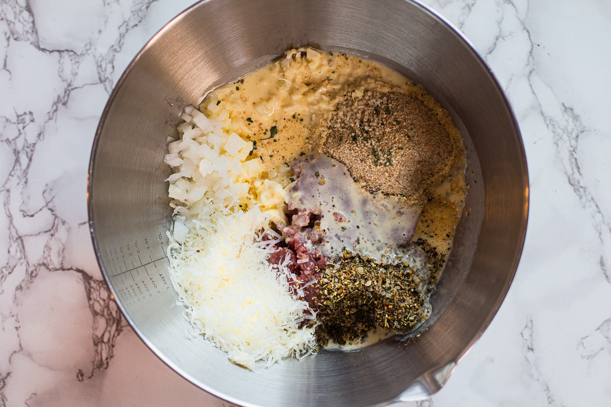 Combing ingredients to make homemade meatballs in a large bowl.
