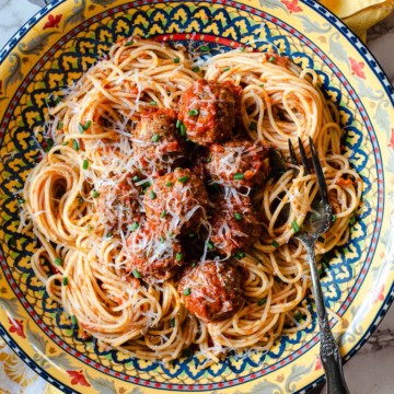 Baked Italian Meatballs in a Colorful pasta bowl with spaghetti and spaghetti sauce
