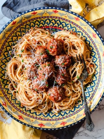 Baked Italian Meatballs in a Colorful pasta bowl with spaghetti and spaghetti sauce