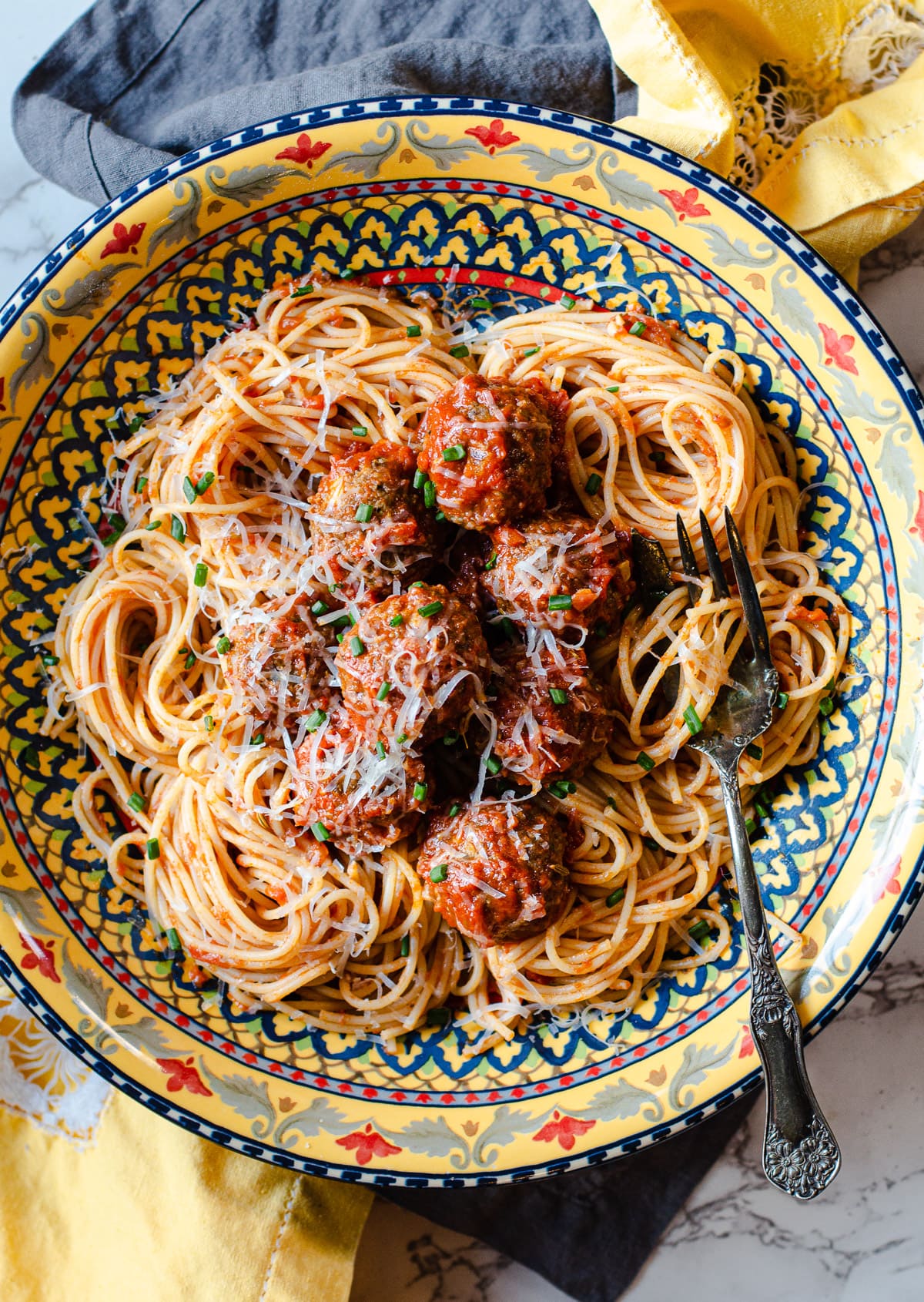 Baked Italian Meatballs in a Colorful pasta bowl with spaghetti and spaghetti sauce