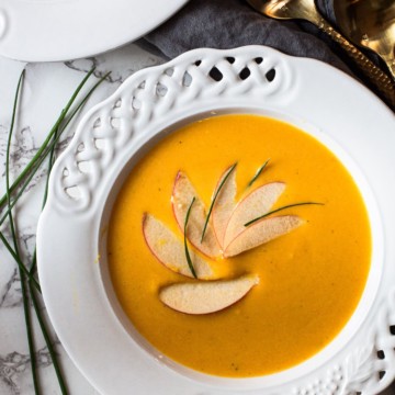 Butternut squash and apple soup garnished with sliced apples and chives