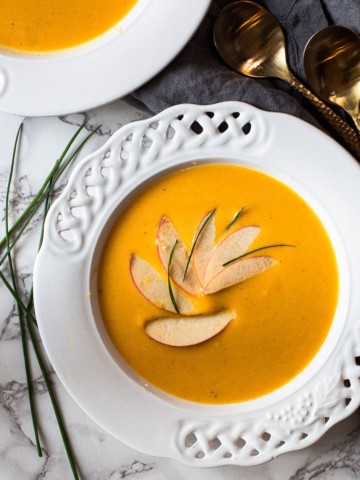 Butternut squash and apple soup garnished with sliced apples and chives