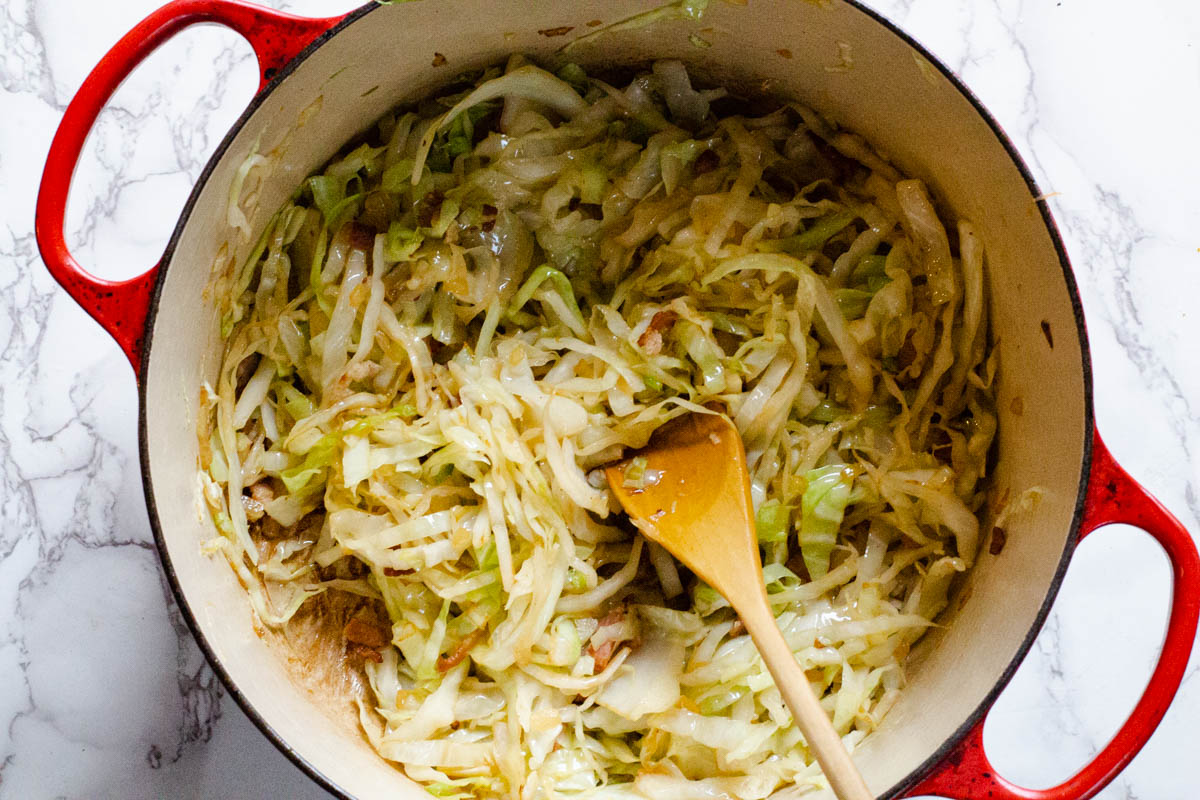 Adding sliced green cabbage to Mexican chorizo soup