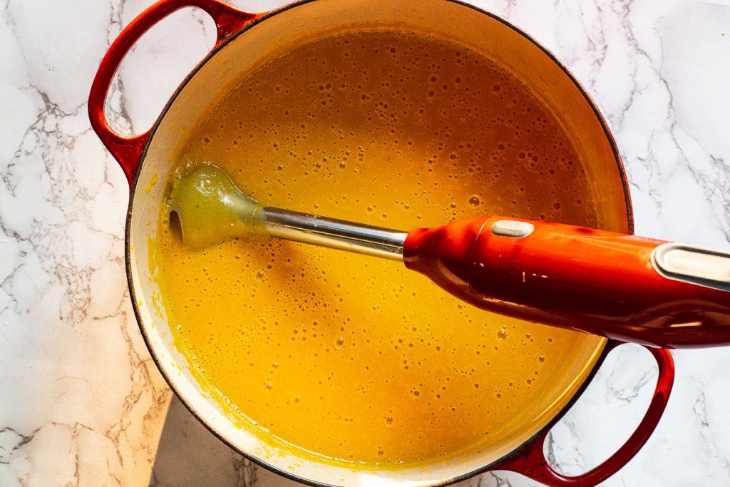 Using an immersion blender to puree butternut squash soup