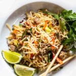 Pork pad thai noodles served on a white plate.