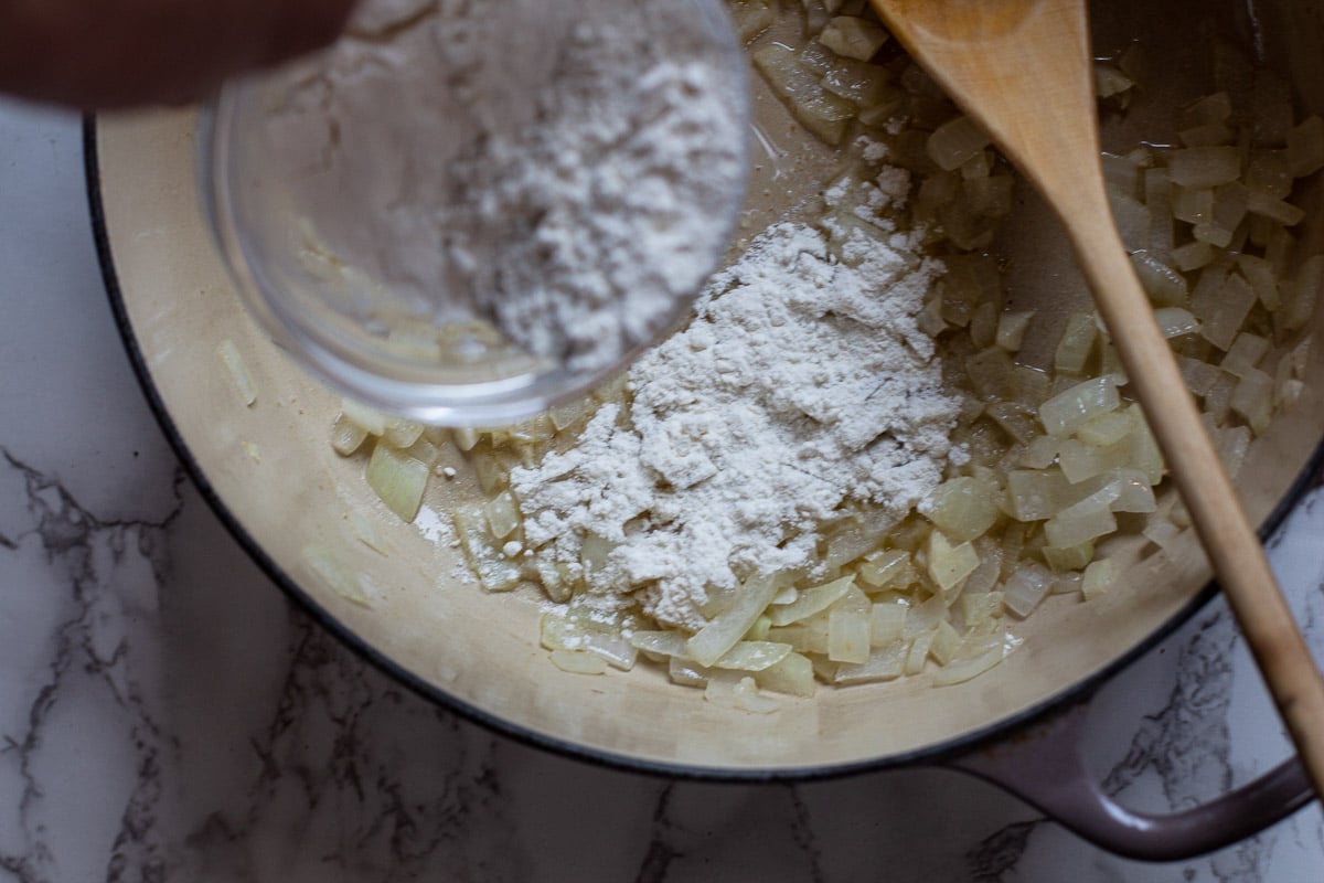 adding flour to onions to make a gravy for carne adovada