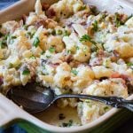 creamed cauliflower casserole with swiss cheese served in a le creuset baking dish