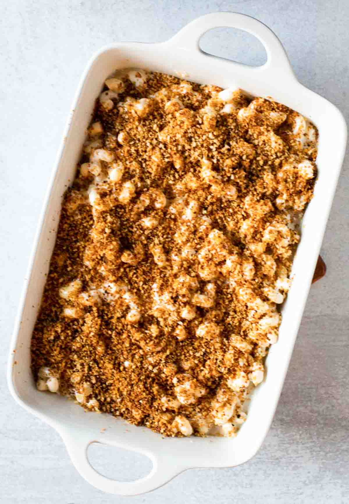 Adding chipotle bread crumb topping to steakhouse mac and cheese.