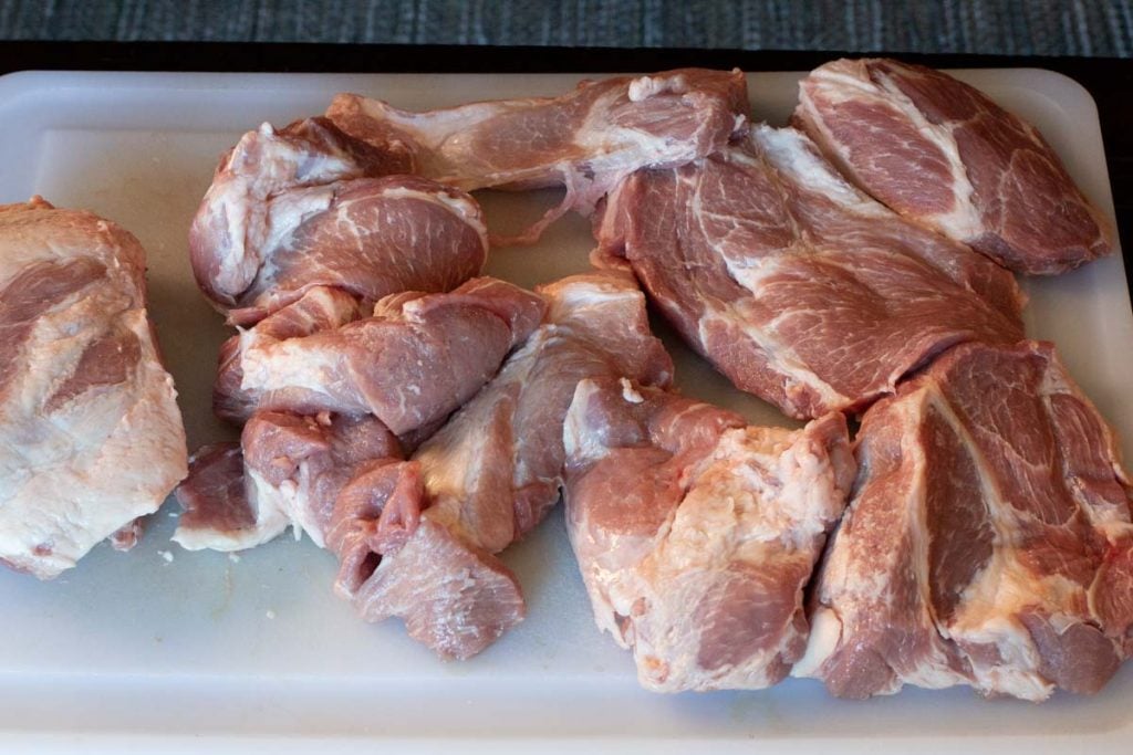 Boneless pork roast cut into slabs ready to marinate and roast.