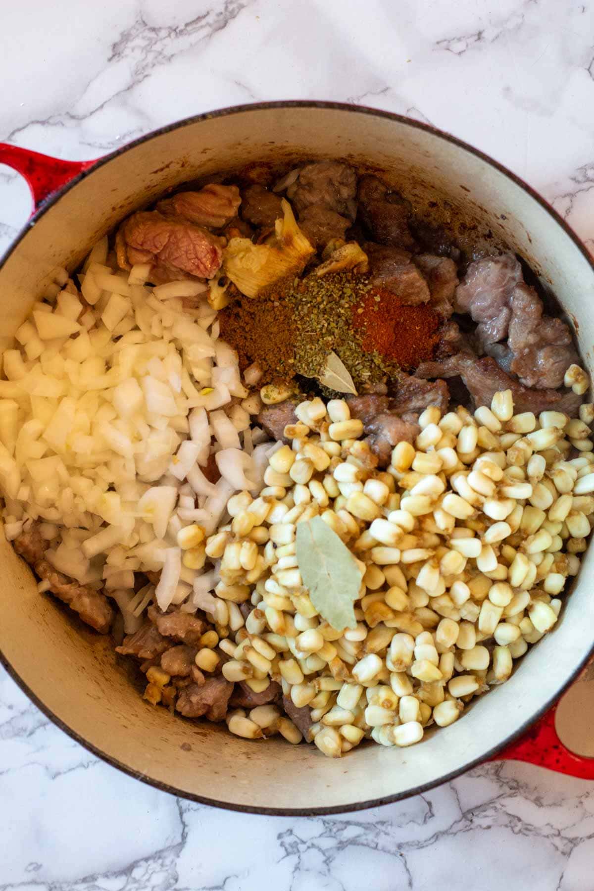 Adding ingredients to dutch oven to make new mexico posole recipe