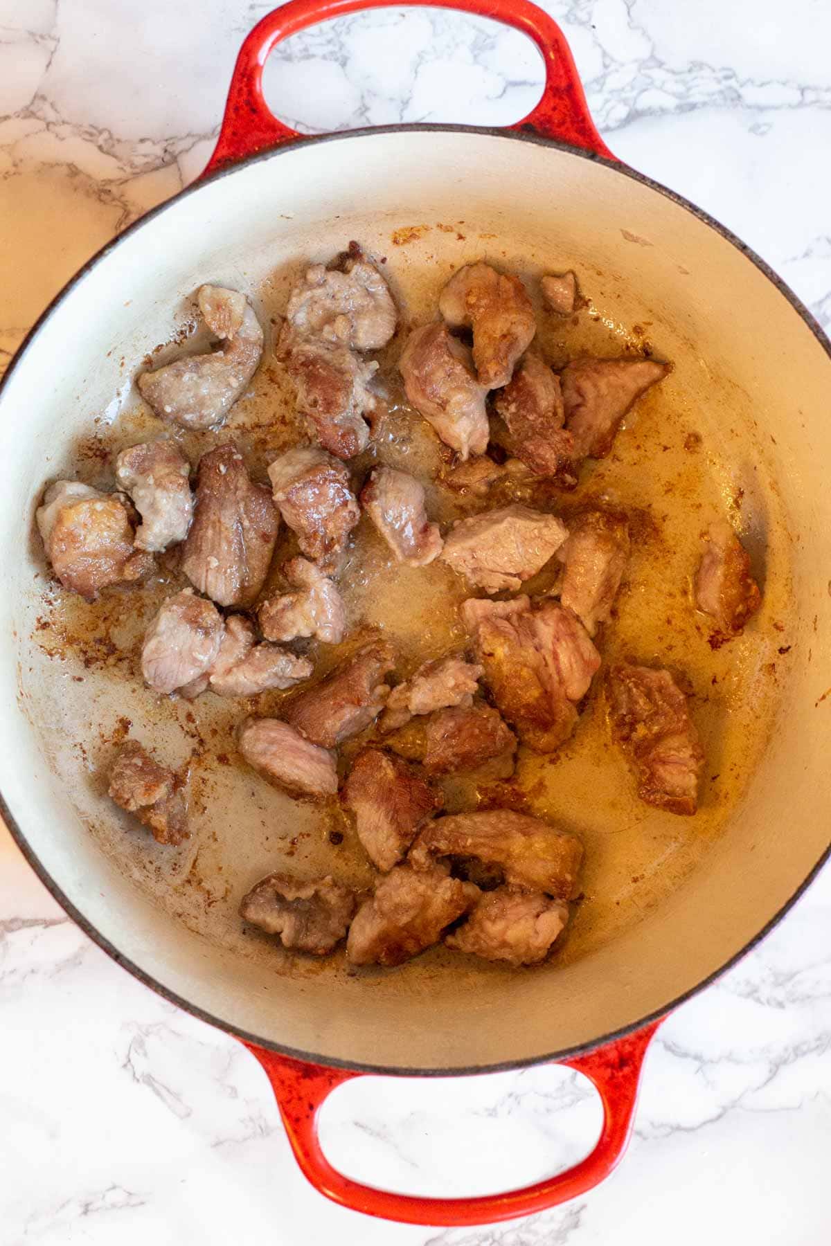 Browning pork in a dutch oven to make posole recipe with pork