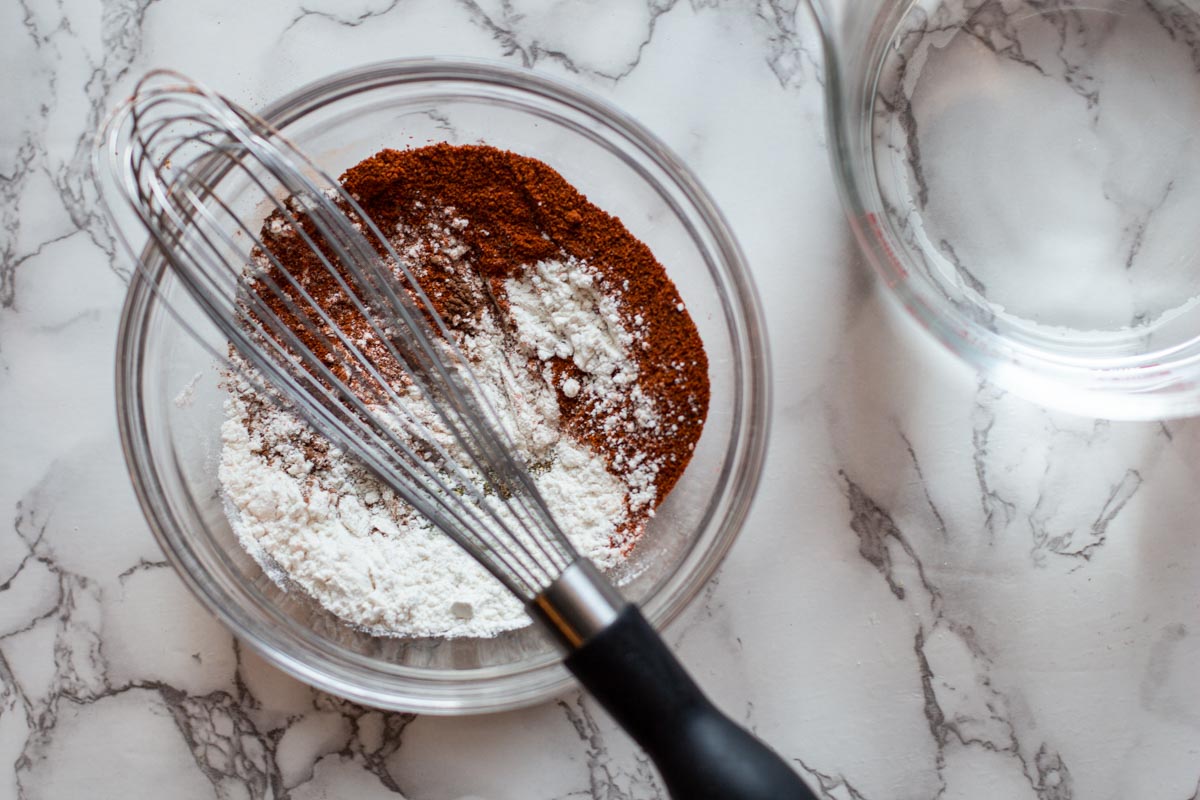 Mixing flour and red chile powder to make Mexican enchilada sauce