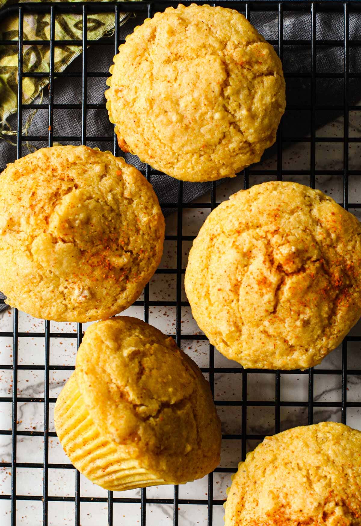 Cornbread muffins cooling on a black wire rack.