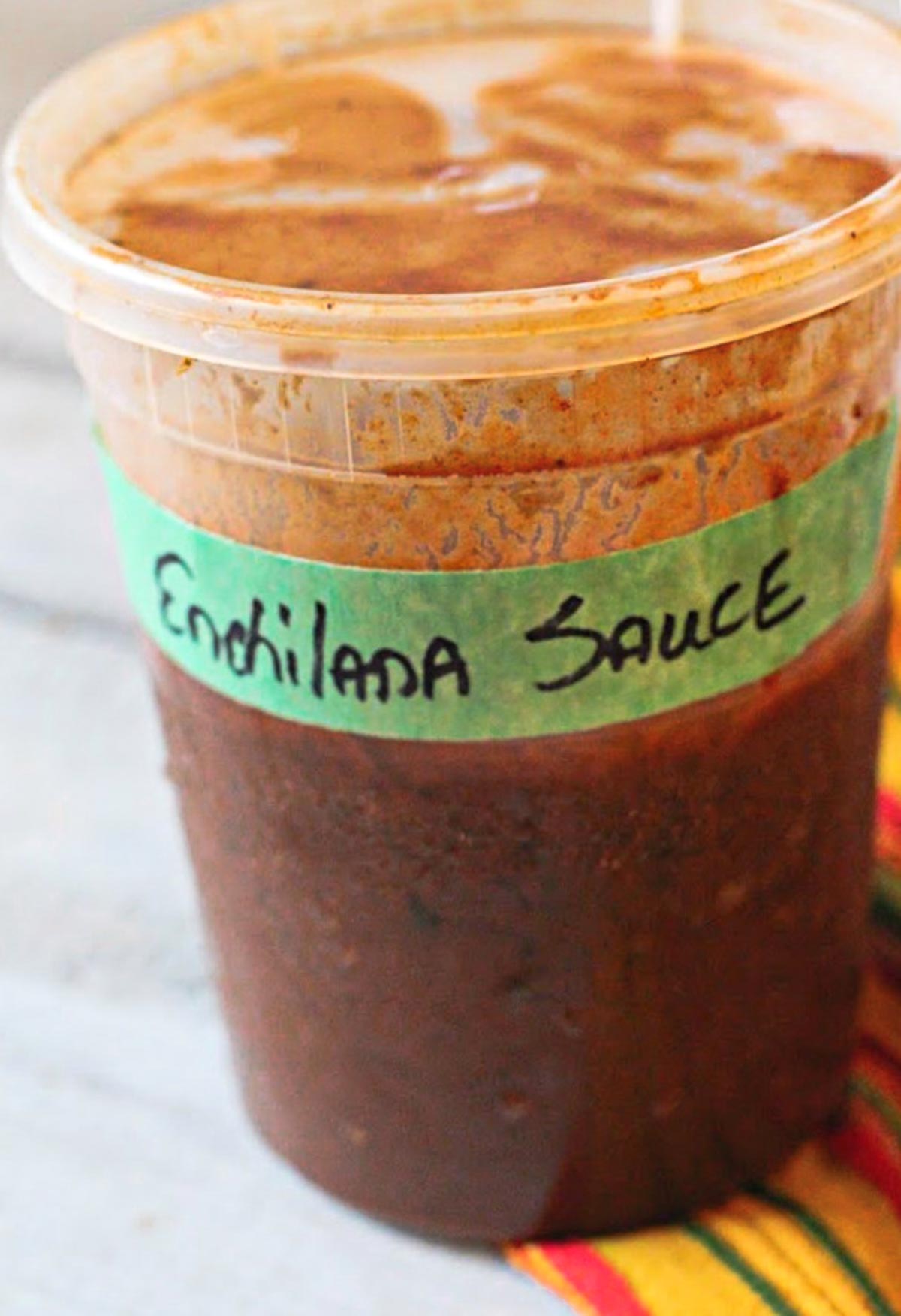 Quick homemade Mexican red enchilada sauce in a deli container