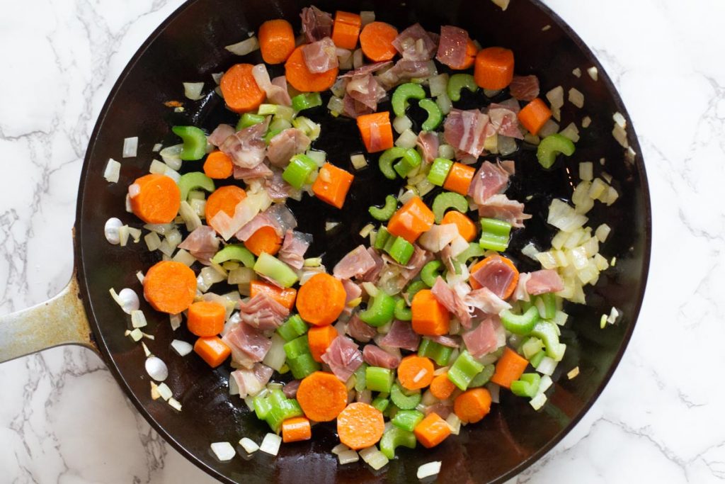 Sauteeing celery carrots, onion and pancetta for creamy chicken soup