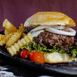 A blue cheese cheeseburger sided with French fries.