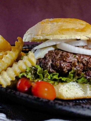 A blue cheese cheeseburger sided with French fries.