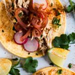 Chicken barbacoa served with corn tortillas and pickled onions.