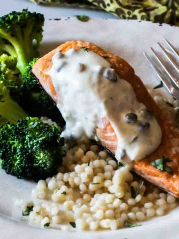 Creamy caper sauce for salmon served over salmon with broccoli.