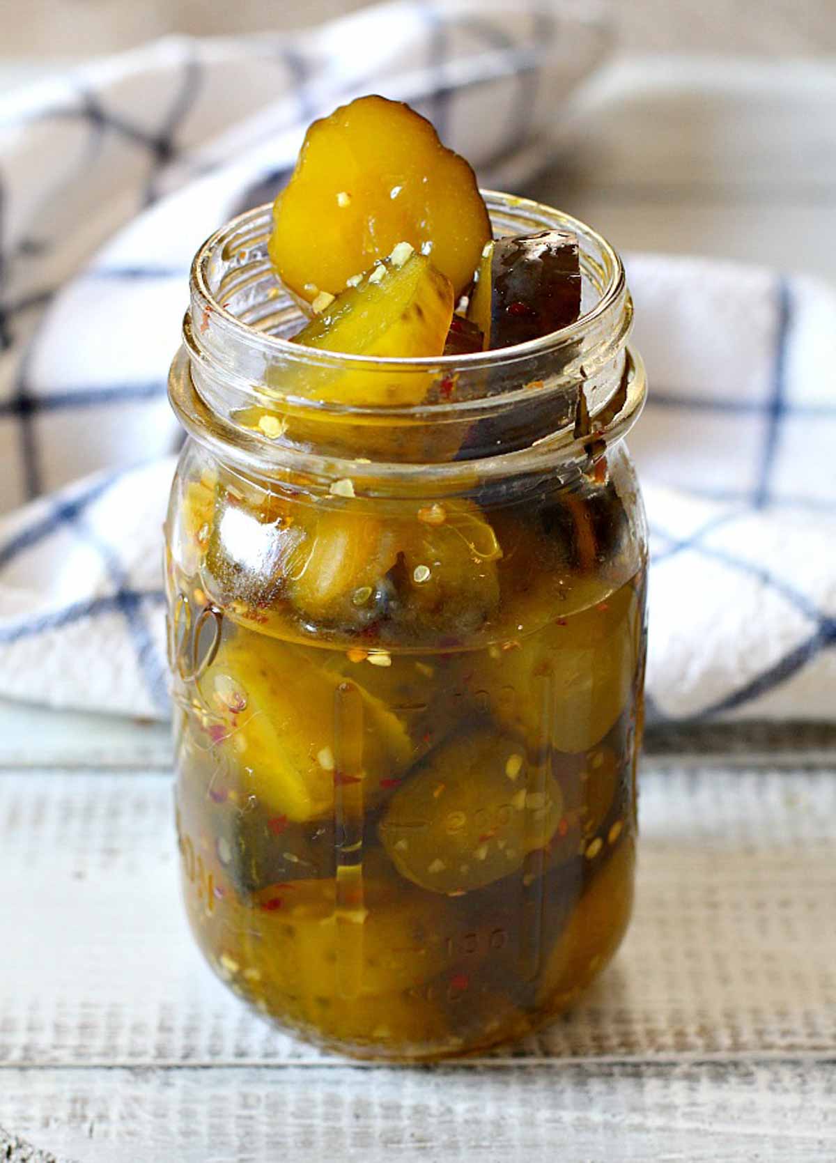 A mason jar filled with homemade sweet and spicy pickles made from store bought dills