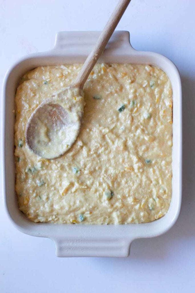 placing batter for cornbread into a le creuset baking dish