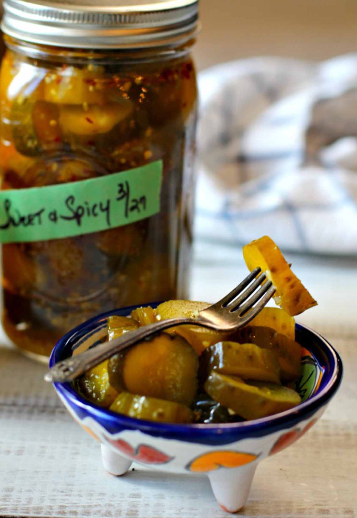 Best spicy pickles. Sweet and spicy pickles in a canning jar and a small Mexican serving bowl.