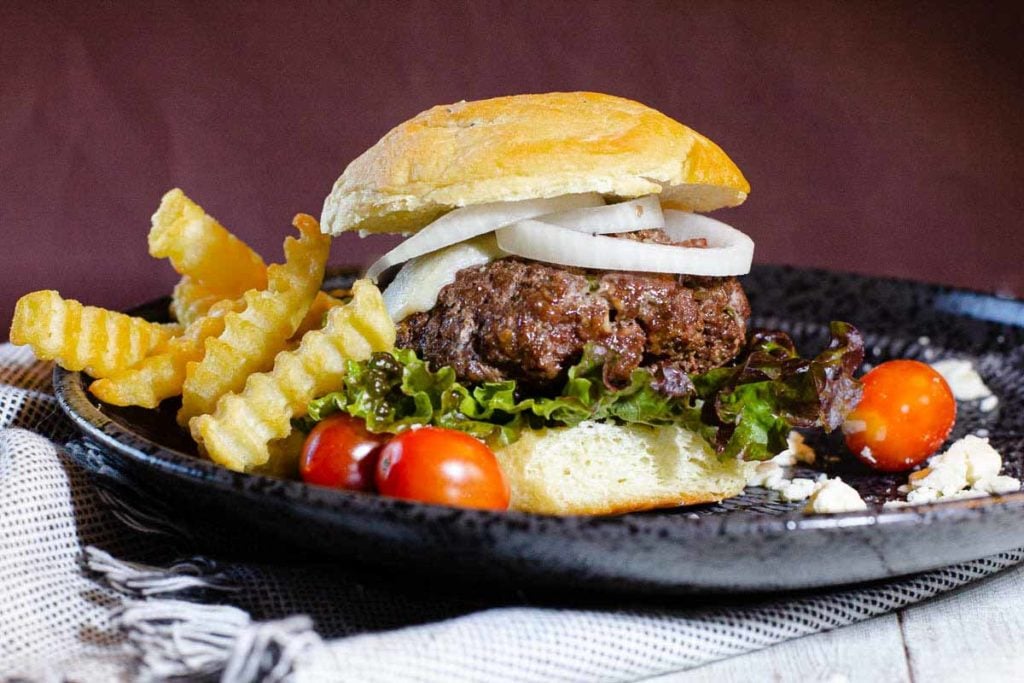 Blue Cheese Burgers served with a salad and fries.