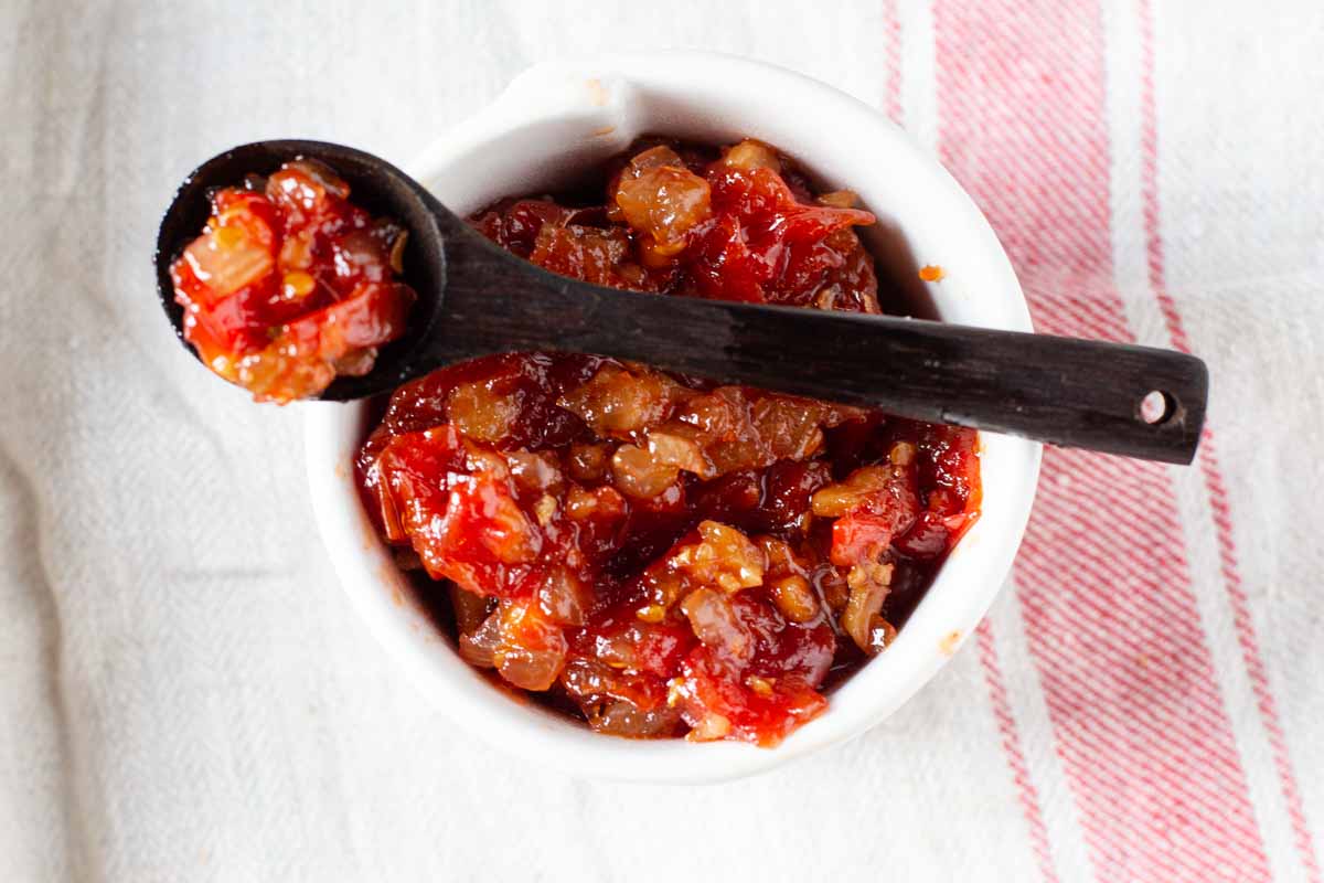 Sweet tomato chutney in a small white crock bowl.