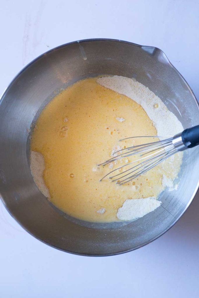 Mixing wet and dry ingredients together to make cornbread