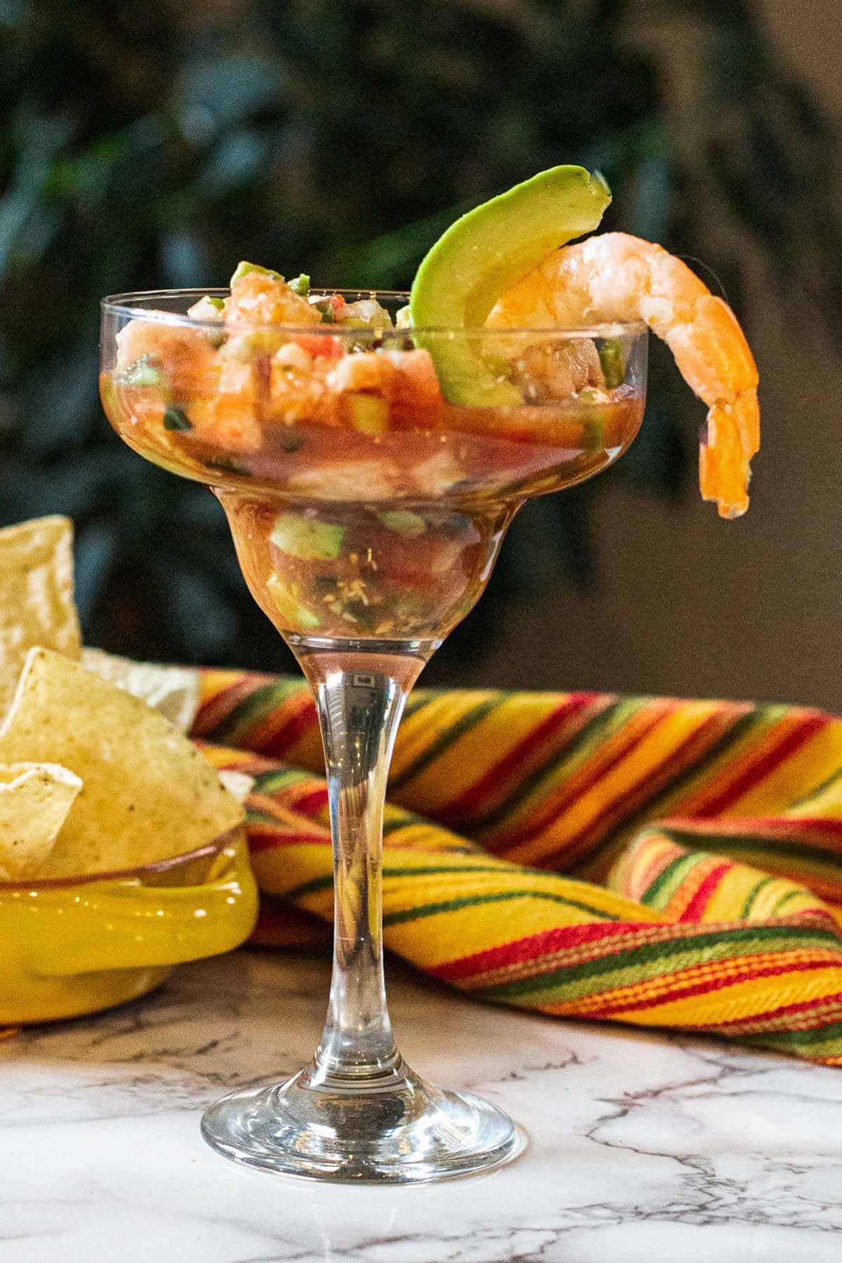 Campechana Mexican Shrimp Cocktail served in a margarita glass and garnished with shrimp and avocado. Served with corn chips