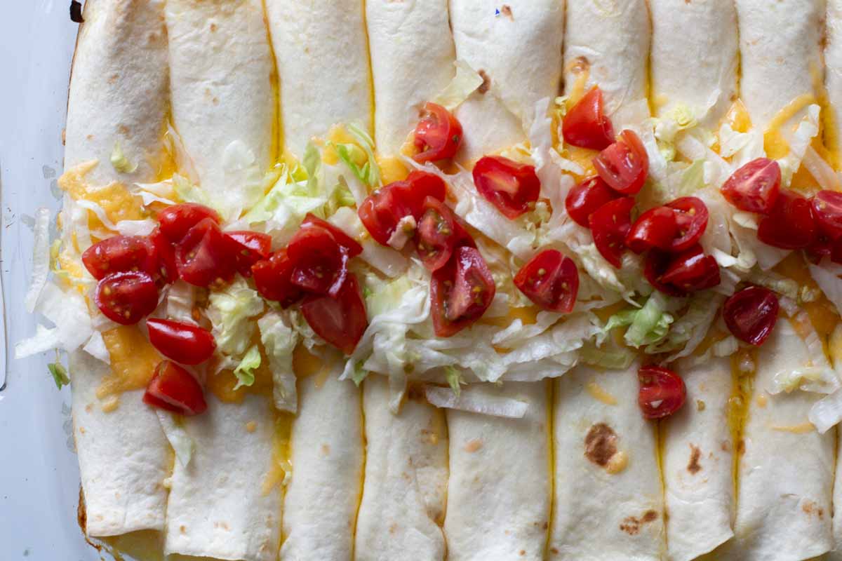 Baked Breakfast Burritos topped with tomatoes and lettuce