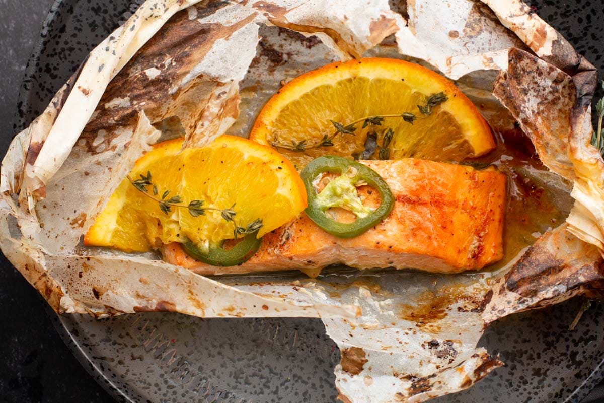 Salmon fillet cooked in parchment paper with oranges and jalapenos