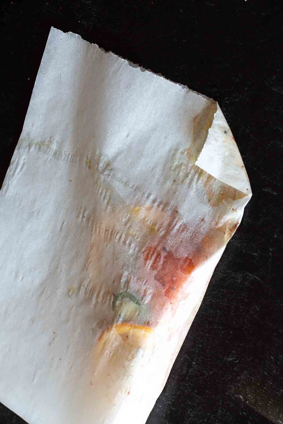 Crimping edges of a parchment paper packet to cook Salmon in parchment.