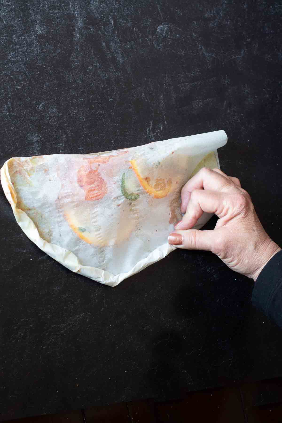 Step 8, how to seal a parchment packet to cook salmon in parchment.