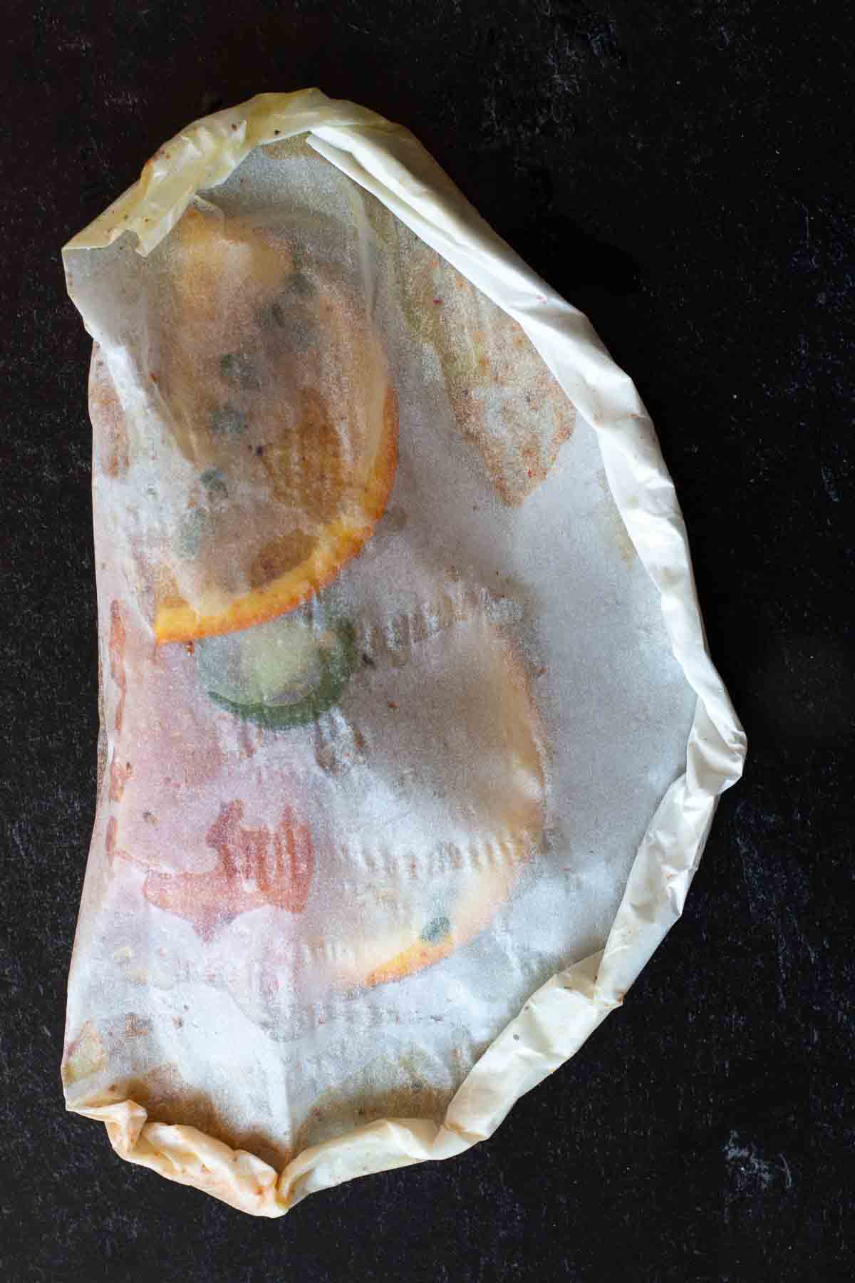 Step 9, A sealed packet of salmon in parchment ready for the oven.