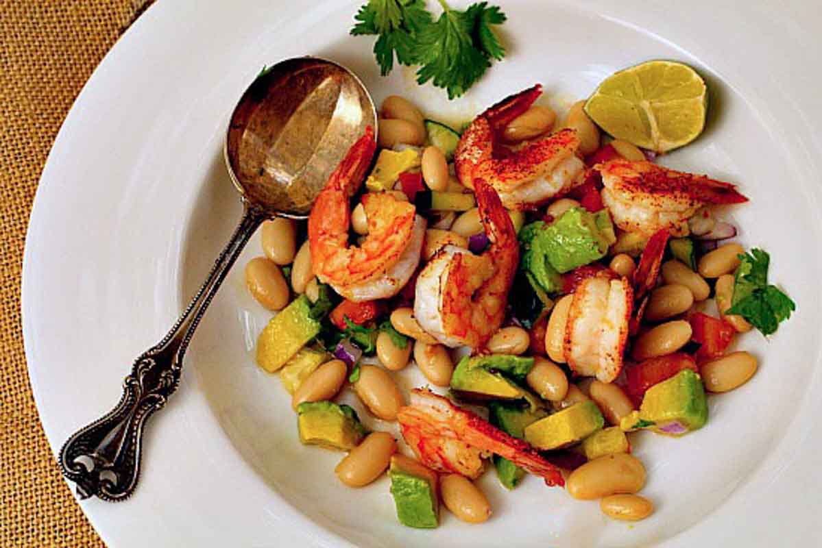 Roasted Shrimp Salad with avocado and canned white beans.Served with a wedge of lime in a white bowl