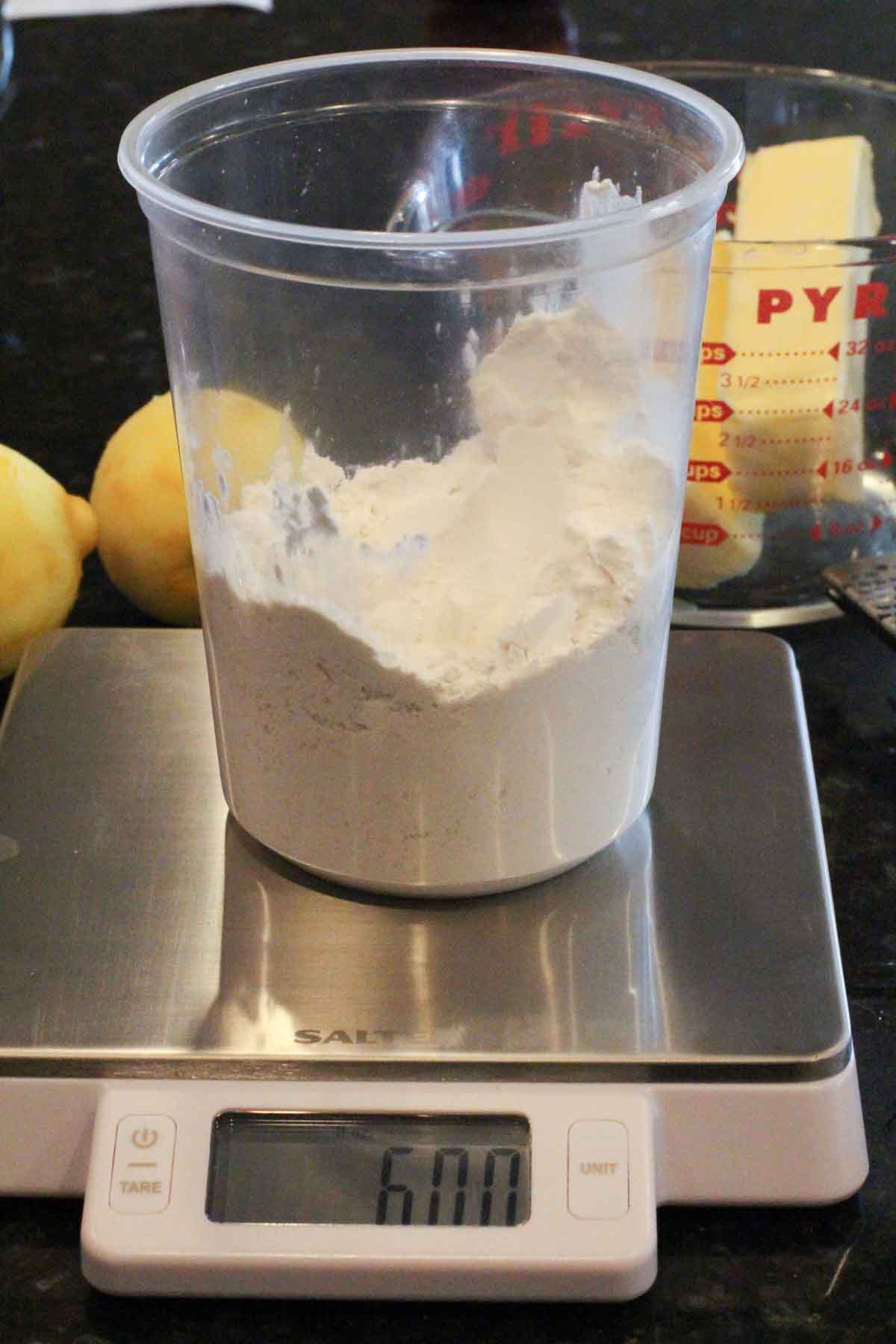 Measuring flour with a food scale to make lemon madeleines