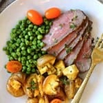 Oven baked tri-tip roast served with potatoes and vegetables.