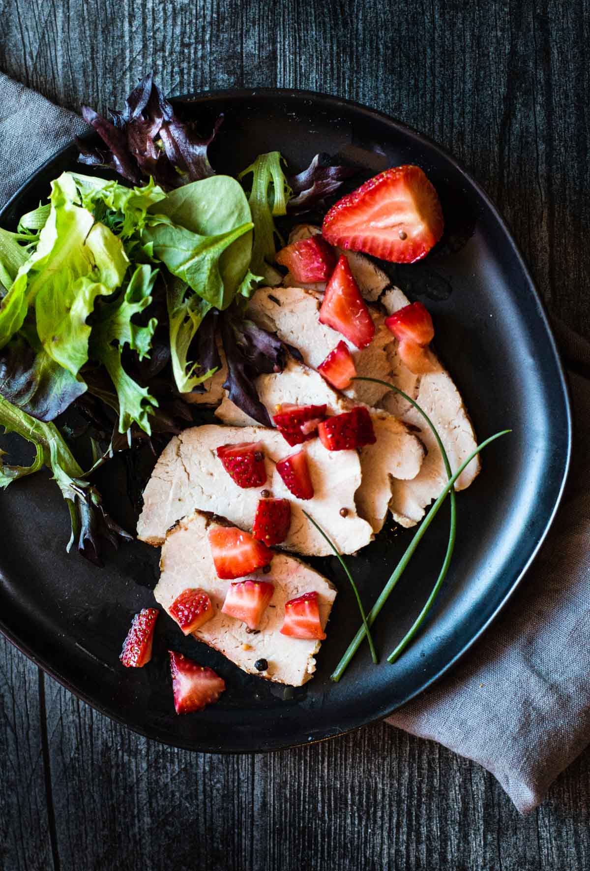 chopped pickled strawberries over grilled pork loin roast with a side salad