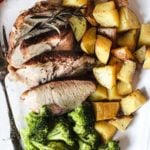Pork roast thats been cooked in a pressure cooker served with fried potatoes and steamed broccoli.
