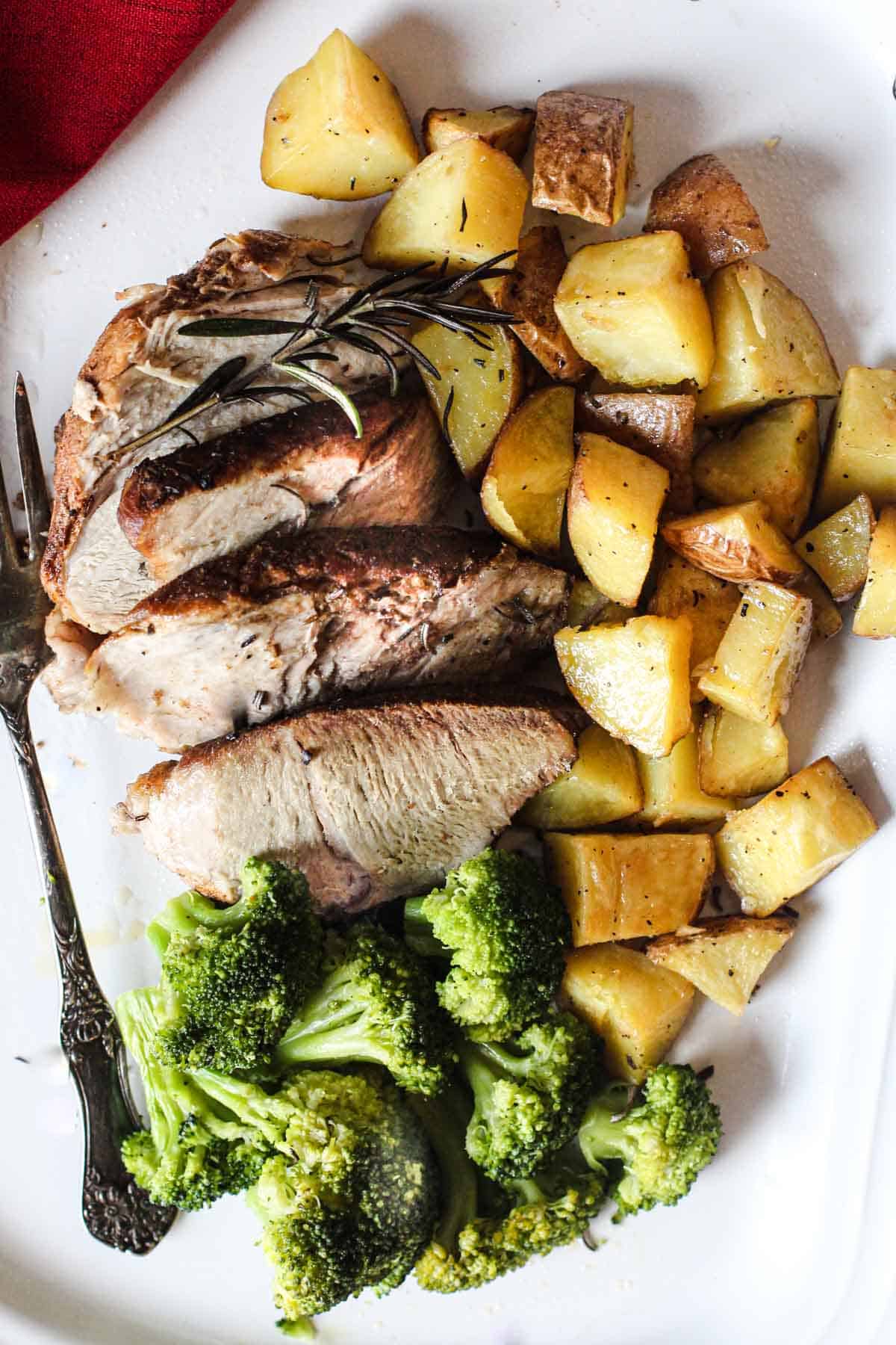 Pork roast thats been cooked in the pressure cooker served with fried potatoes and steamed broccoli