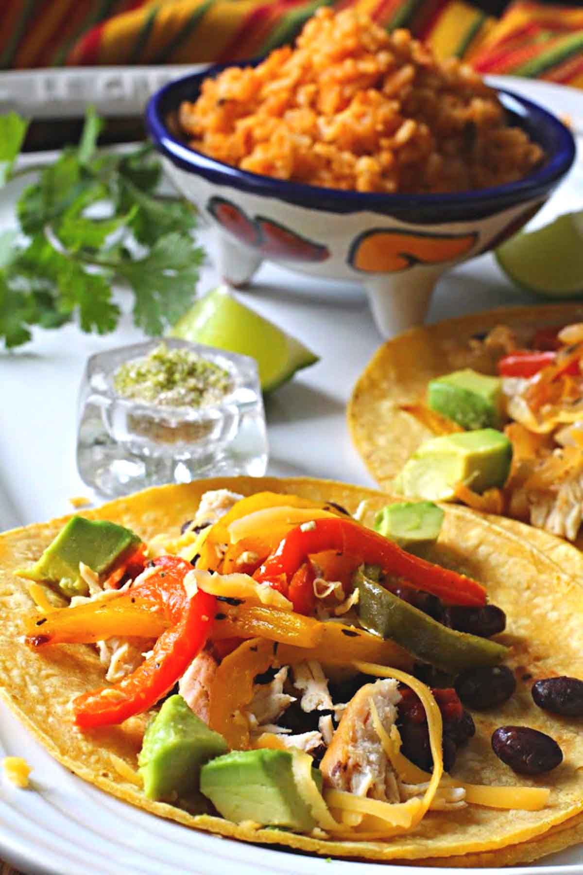Roasted bell pepper tacos on soft corn tortillas with Spanish rice, served on a white Le Creuset platter
