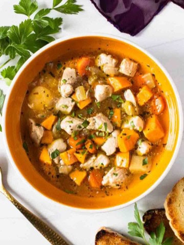 Chicken sweet potato soup served with bread.