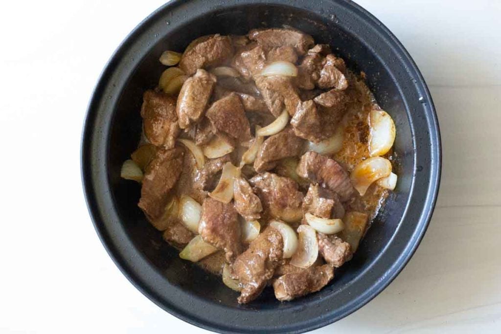 Cooking lamb and onions in a tagine pot