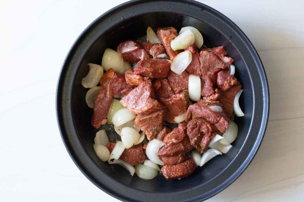 lamb and onions cooking in a tagine pot